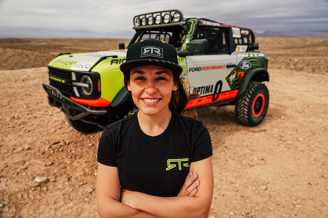 Bailey Campbell standing in front of her Ford Bronco 4600 before the Mint 400 race