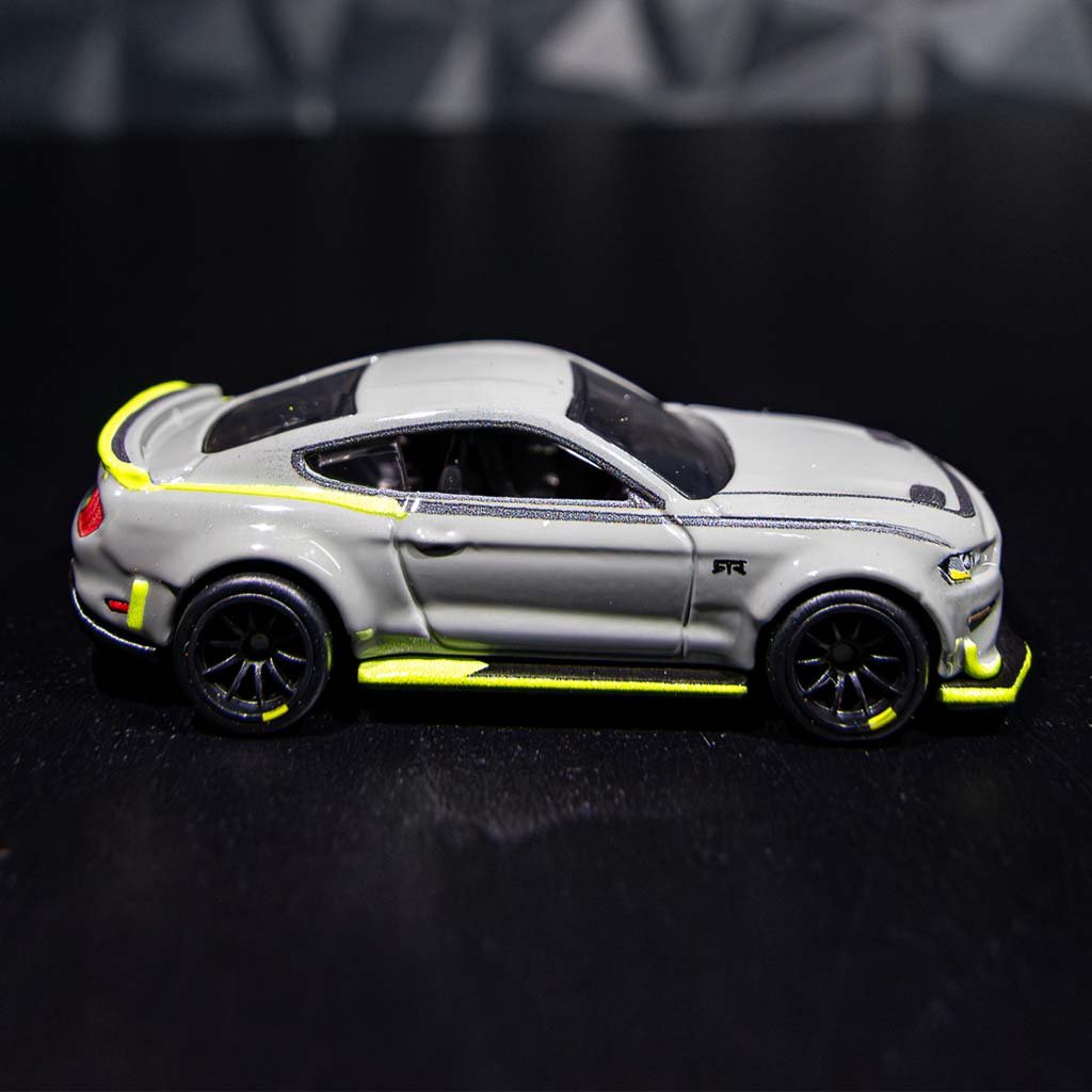Close-up of the 10th Anniversary Mustang RTR Spec 5 Hot Wheels toy car, showcasing detailed wheels and unique decals.