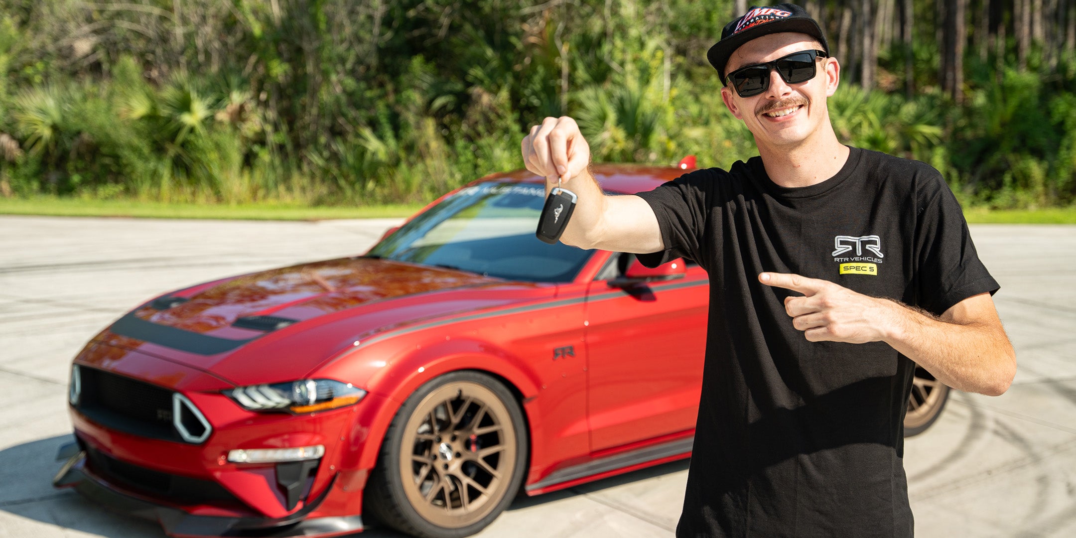 Adam LZ standing in front of his Mustang RTR Spec 5