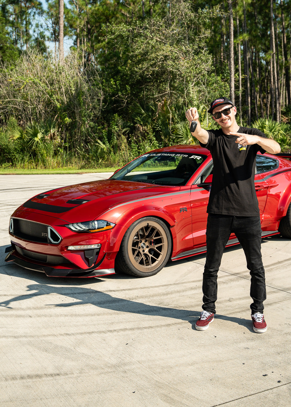 Adam LZ standing in front of his Mustang RTR Spec 5