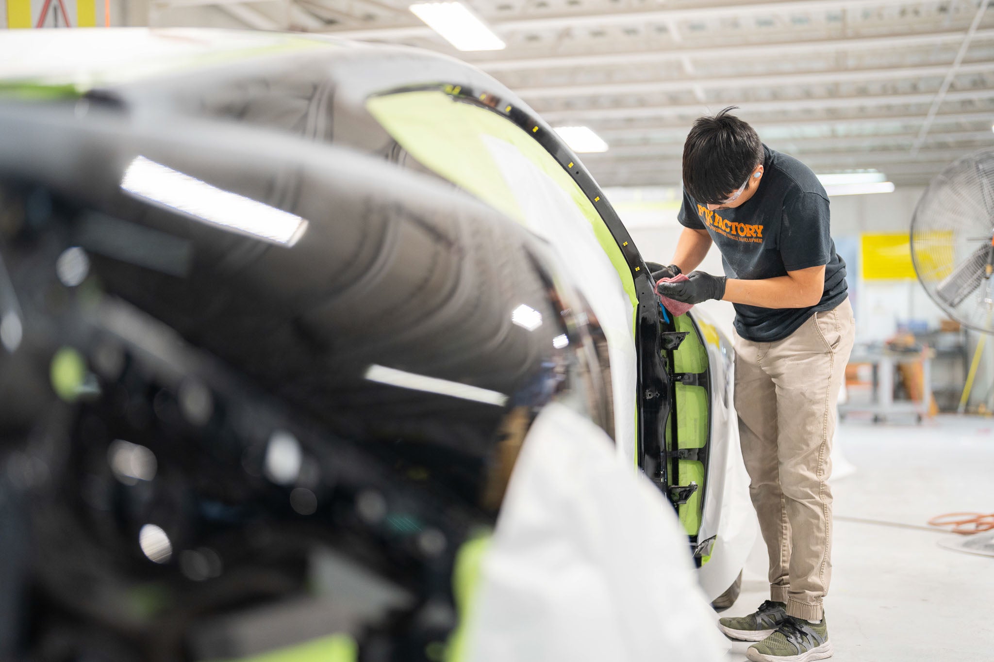 A man works on a Mustang in a shop preparing for Mystichrome paint process