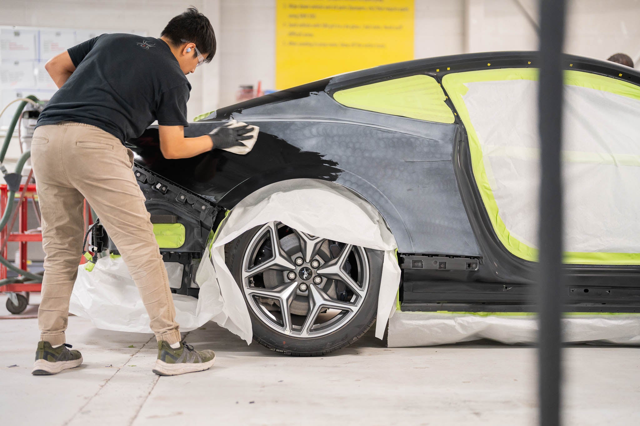 A man working on a Mustang in a shop preparing for Mystichrome paint process