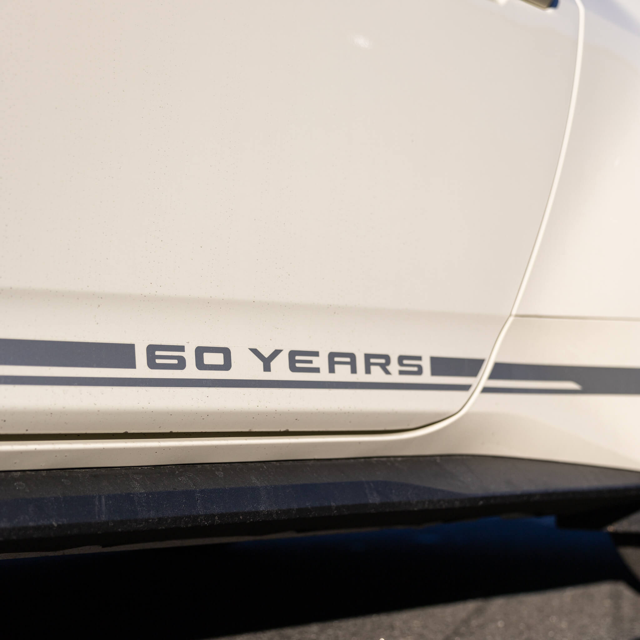 A close up photo of the door graphics on a Wimbledon white 60th anniversary Mustang 