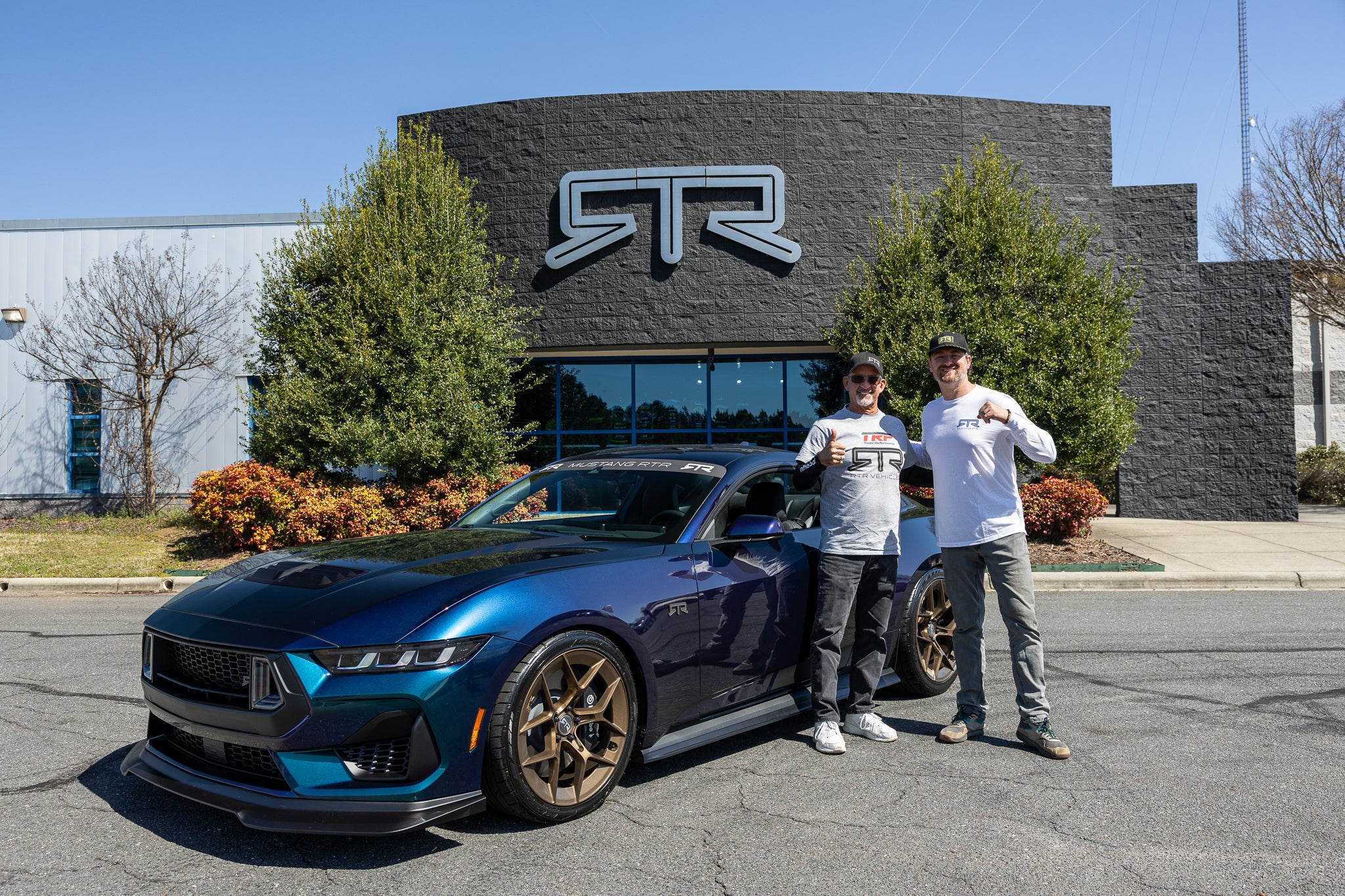 Vaughg Gittin Jr poses for a picture with a new 2025 Mustang RTR Spec 3 in Mystichrome