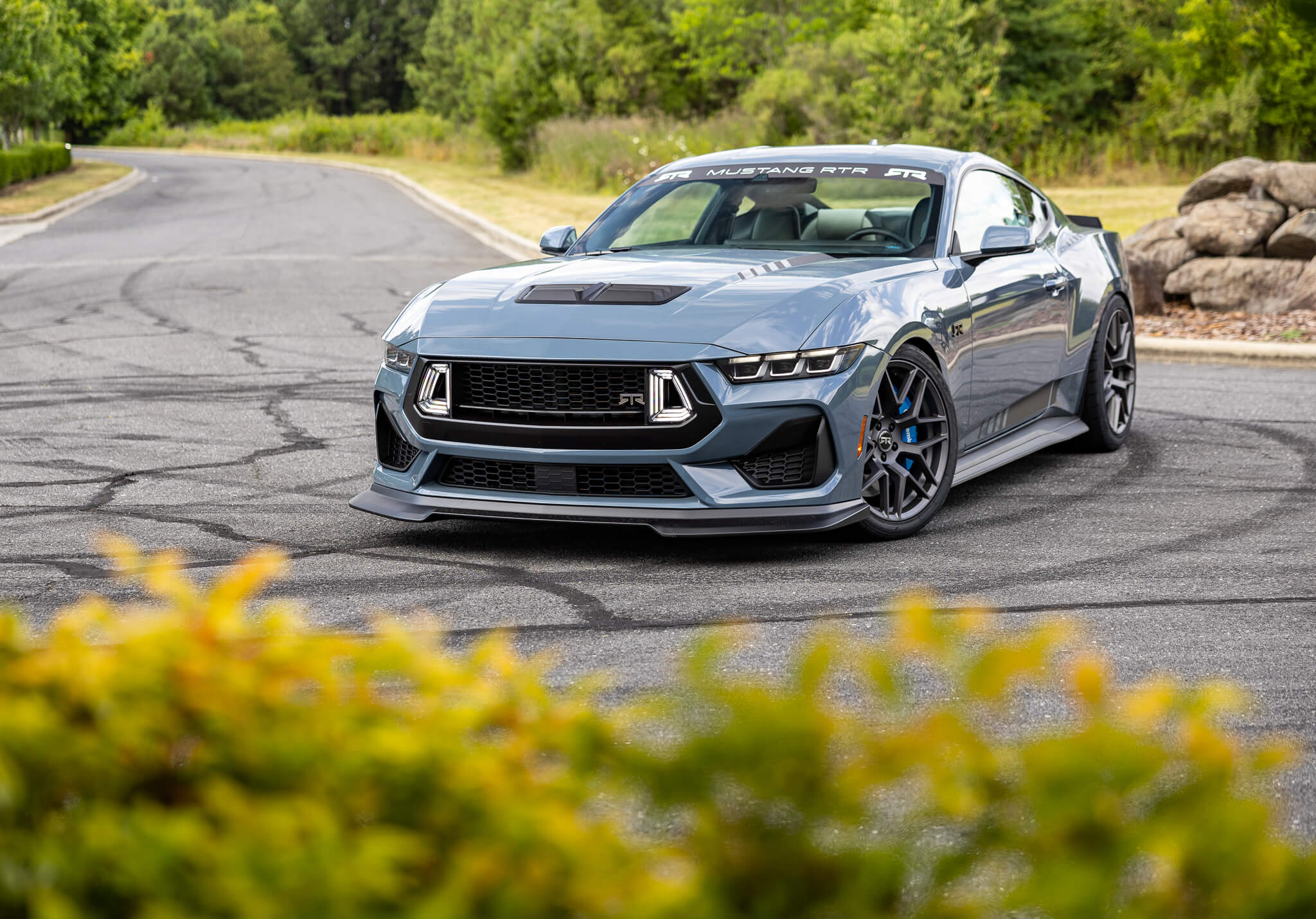 A vapor blue 2024 s650 Mustang RTR Spec 3 on an asphalt road