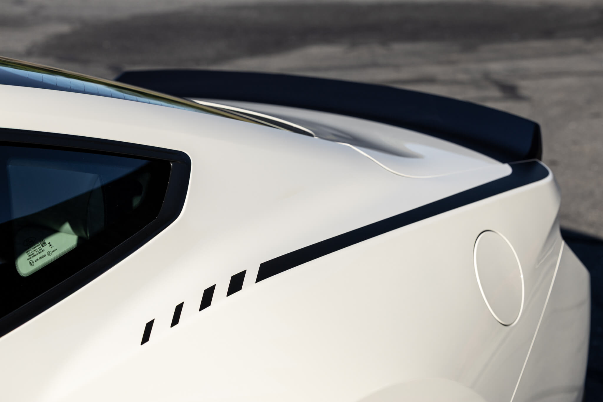 A close up photo of a 2025 Wimbledon white 60th Anniversary Mustang RTR with RTR graphics