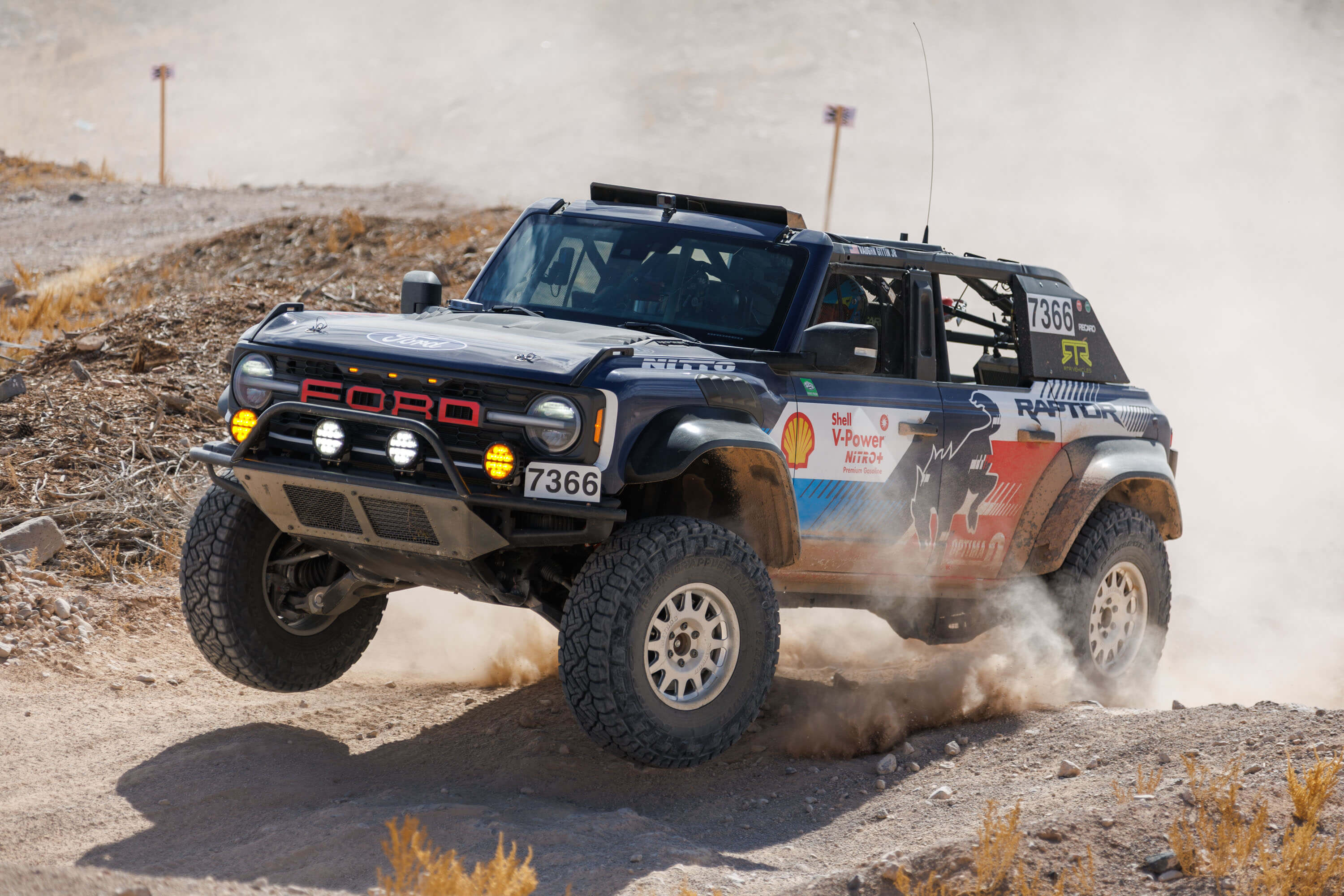 Vaughn Gittin Jr. tackles a rocky incline at the Mint 400, showcasing the Bronco Raptor's suspension and off-road capability in the challenging terrain.