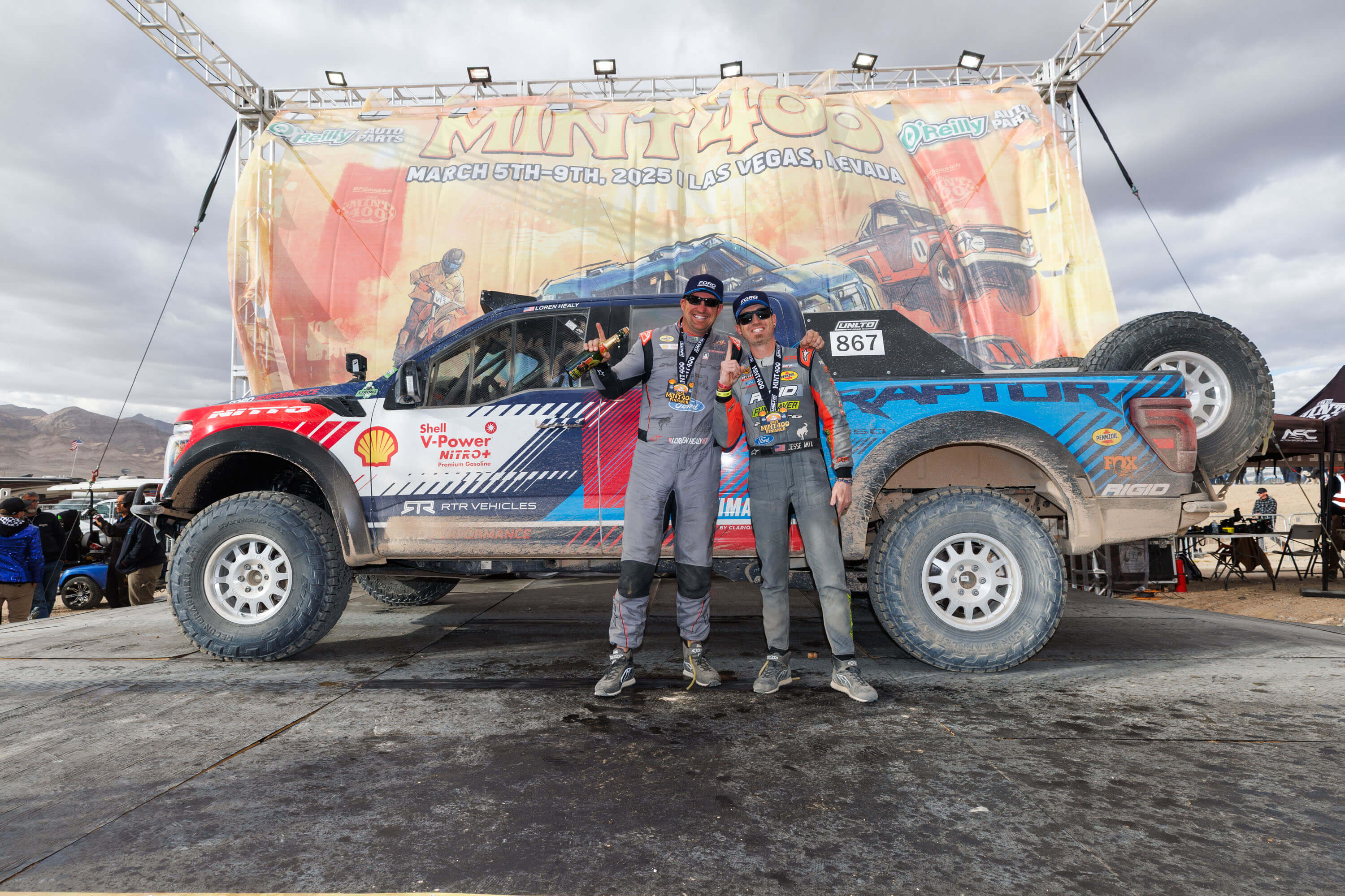 Loren Healy celebrates on the podium with his RTR Vehicles Off-Road Ford F-150 Raptor after securing a first place finish at the Mint 400