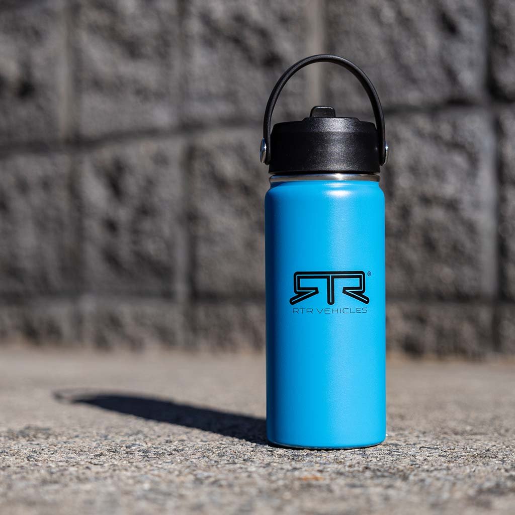 RTR 16oz Tumbler on concrete surface, featuring a black lid with integrated straw, showcasing its sleek design and practical functionality for daily hydration.