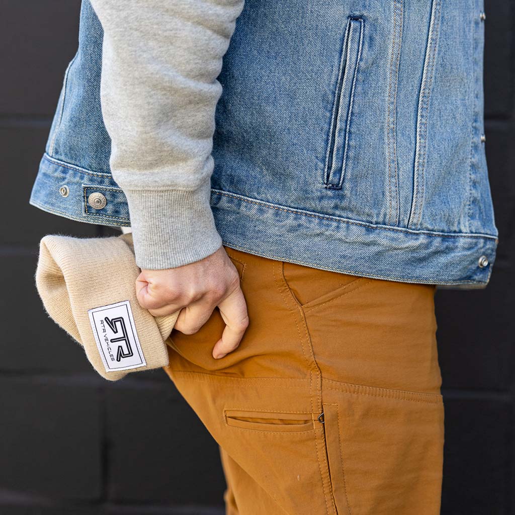 Person holding an RTR Beanie in their pocket, showcasing its compact, versatile design and stitched RTR logo, emphasizing its snug fit and casual style.