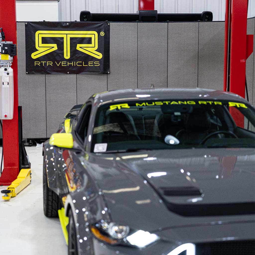 RTR Garage Banner displayed in a garage with pre-installed grommets for easy mounting, ideal for automotive enthusiasts.