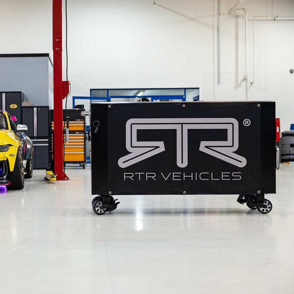 RTR Garage Banner displayed in a garage setting, featuring pre-installed grommets for mounting. Ideal for car enthusiasts to enhance their workspace!