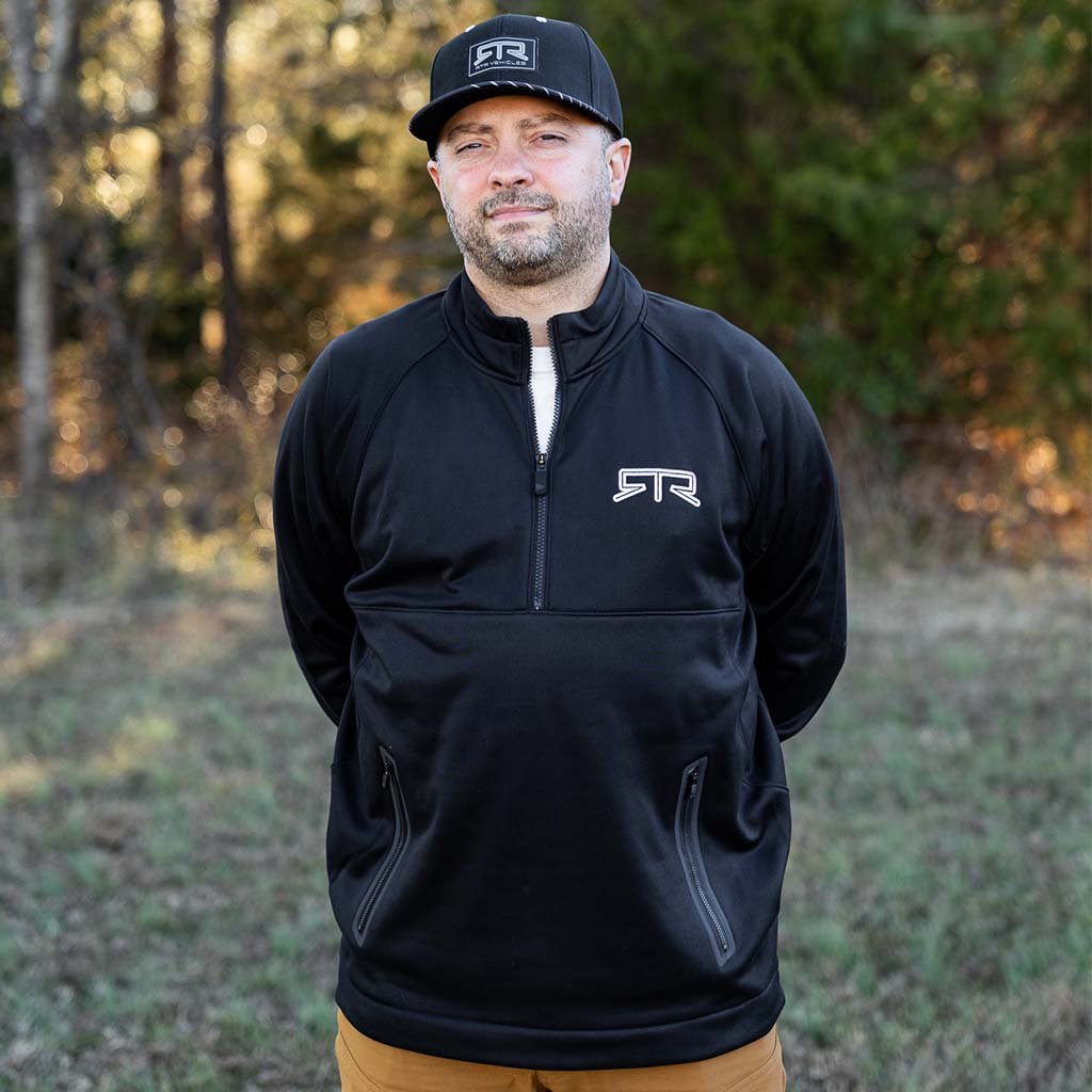 Man wearing RTR Quarter Zip Pullover with quarter zipper and embroidered logo, showcasing a stylish and comfortable design suitable for various casual occasions.