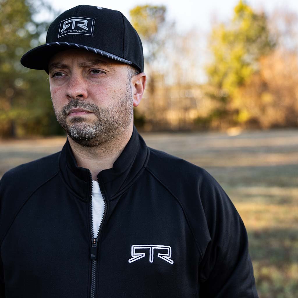 Man wearing an RTR Quarter Zip Pullover with a black hat, showcasing the pullover’s quarter zipper and embroidered RTR logo on the chest.