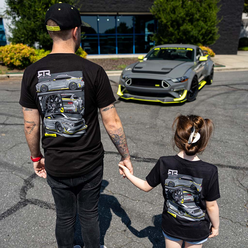 Man and young girl holding hands, looking at a Mustang RTR Spec 5 car; both wearing the Spec 5 10th Anniversary Tee.